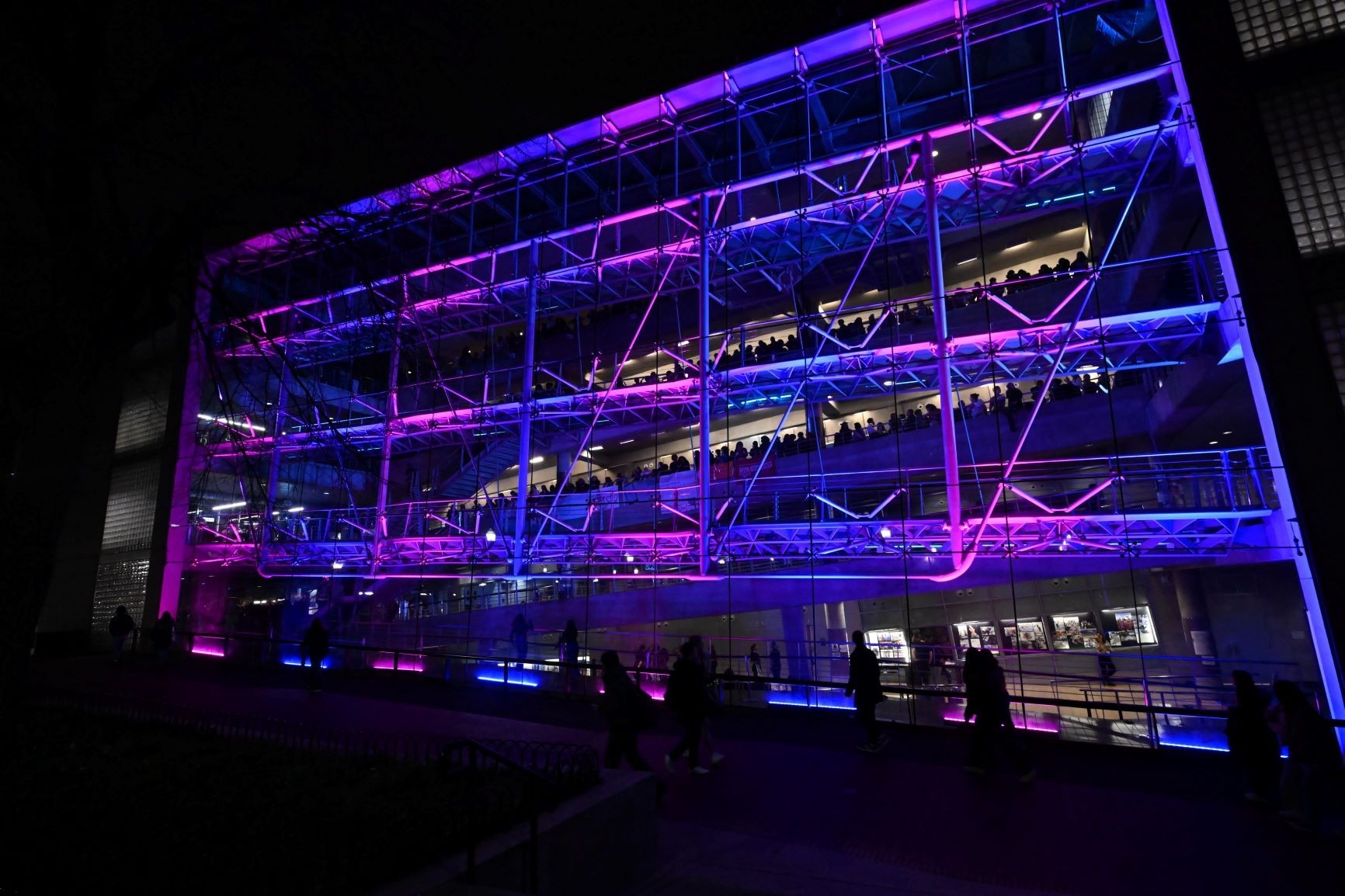 Exterior of Lerner Hall, brightly lit in lights, during the night of the 2023 Glass House Rocks event.